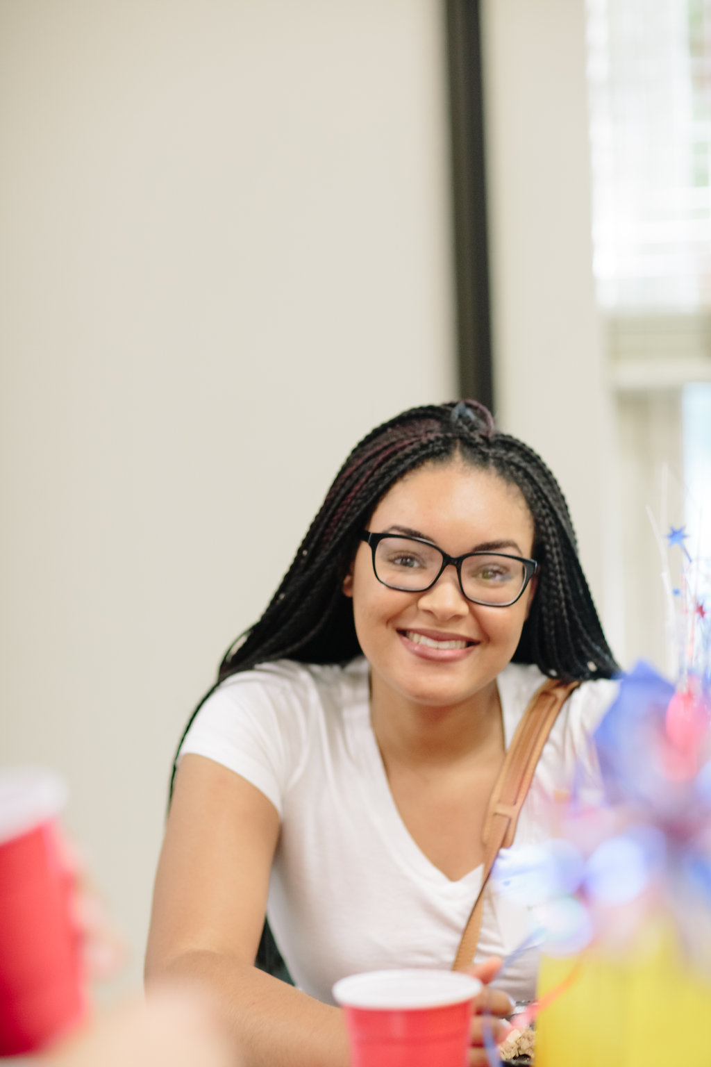 Woman with glasses sitting in a chair smiling at a party