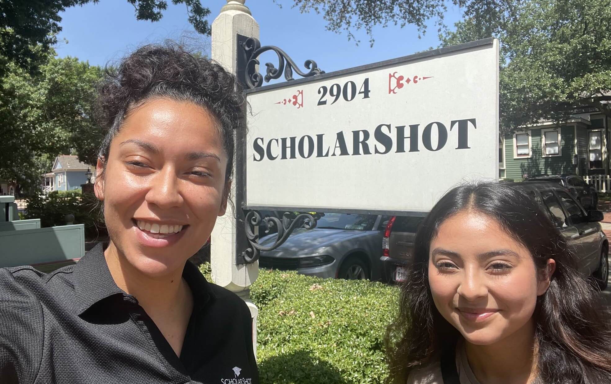 Kassandra and Lesly in front of ScholarShot sign